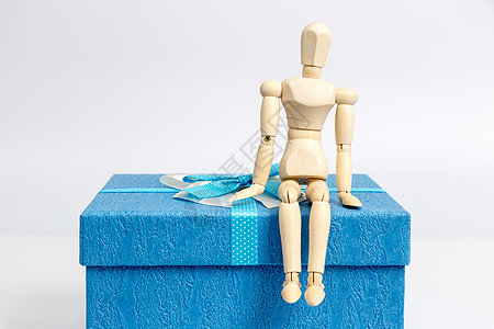传统包装礼物盒与坐着的人偶背景