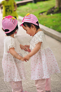 双胞胎手牵手玩耍背景图片