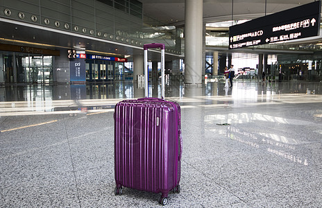 商务旅行机场大厅内的紫色行李箱背景