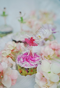 花丛中的跳舞姑娘粉色杯子蛋糕特写图片