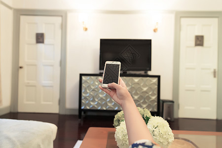 家居生活女性手控制手机背景图片