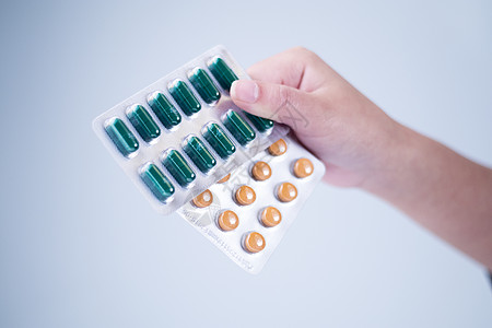 药片黄色手拿一排药片单拍背景