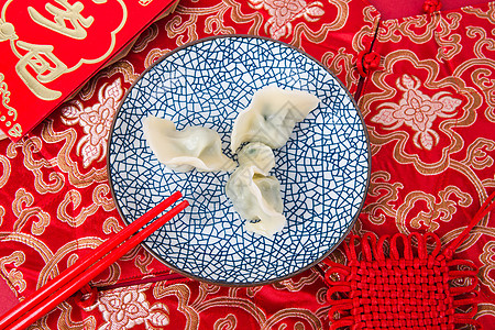 新春过年冬至红色背景上的一盘饺子图片