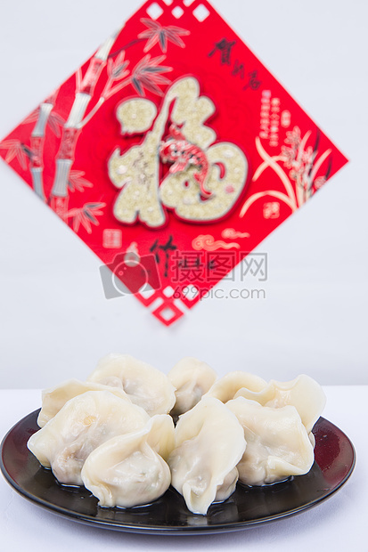 冬至新春节日福字背景前的一盘饺子图片