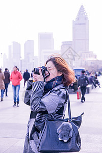 城市街头女性摄影师在拍照背景图片