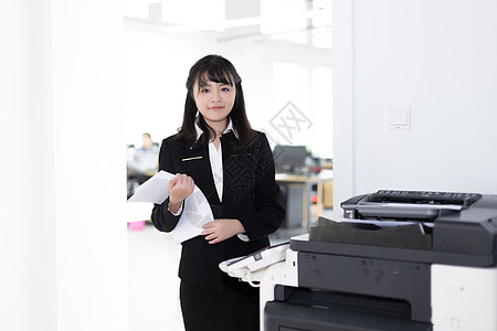 复印机旁的女职员背景图片