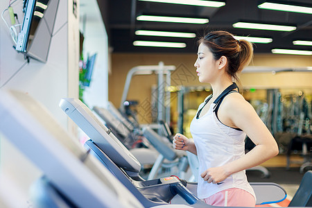 健身房女性用跑步机的美女背景