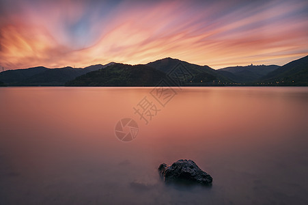 晚霞中湖边的石头图片