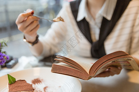 咖啡馆内女孩边吃甜品边看书图片