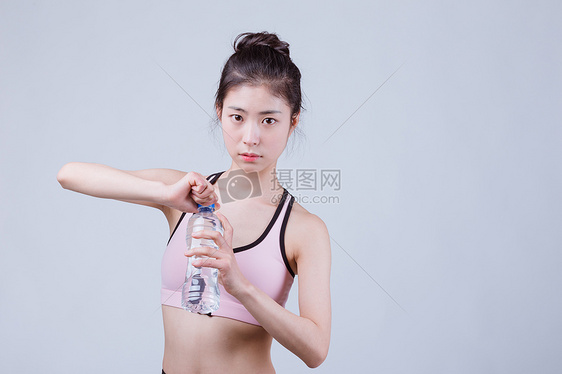 青春运动美女休息拿矿泉水图片