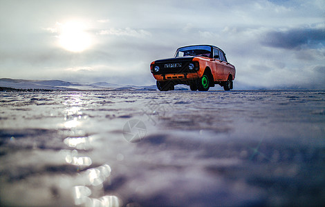 橙色吉普车汽车冰面上行驶的老式轿车 在资本寒冬中前进背景