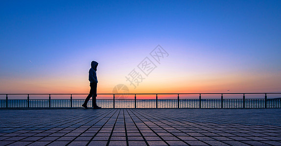 夕阳下行走的人背景图片
