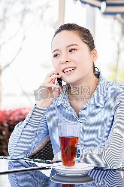 年轻女子在咖啡馆打电话图片