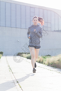 夕阳下跑步运动的年轻女性高清图片