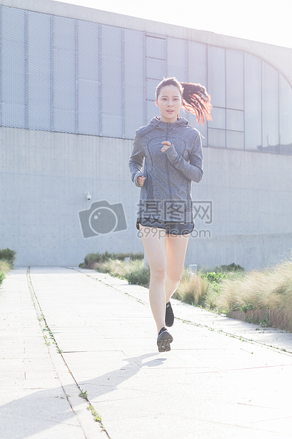 夕阳下跑步运动的年轻女性图片