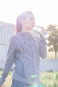 健身女子喝水年轻女性户外运动休息喝水背景