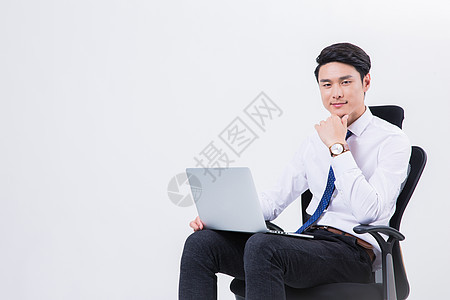 商务男士在办公椅上用电脑背景图片