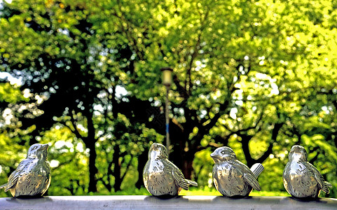 日本大阪城公园里的绿树下的鸟儿雕塑图片