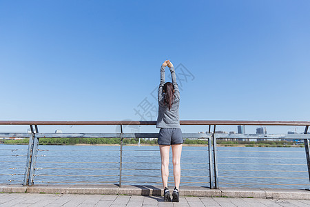 运动女孩阳光下拉伸身体背景图片