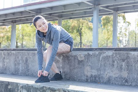 运动女孩户外休息系鞋带图片