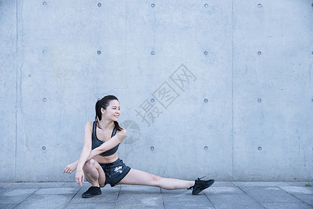 户外运动女孩热身压腿图片