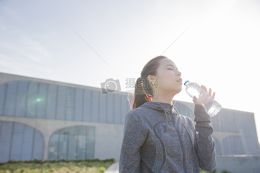 落日运动女孩休息喝水图片