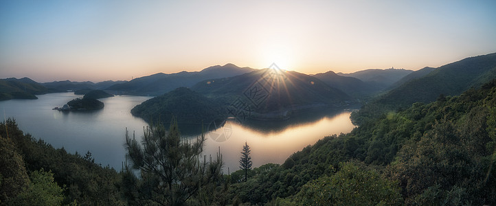 湖边远山的太阳星芒背景图片