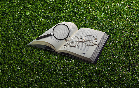 草地风格放大镜和书背景图片