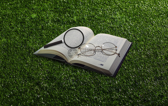 草地风格放大镜和书图片