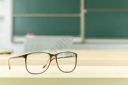 教室里书桌上的眼镜特写背景