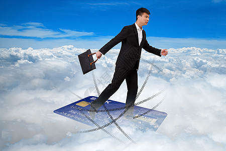 拿着包踩着卡飞行在云端的商务男士图片