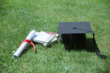 大学草地上的书本证书学士帽毕业季高清图片素材