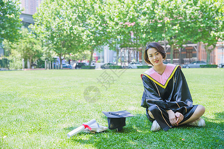 坐在草地上清新学士服女学生图片
