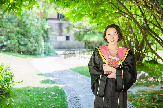 毕业季穿学士服抱书的学生图片