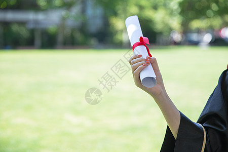 大学学士帽草地上手拿毕业证的毕业生背景