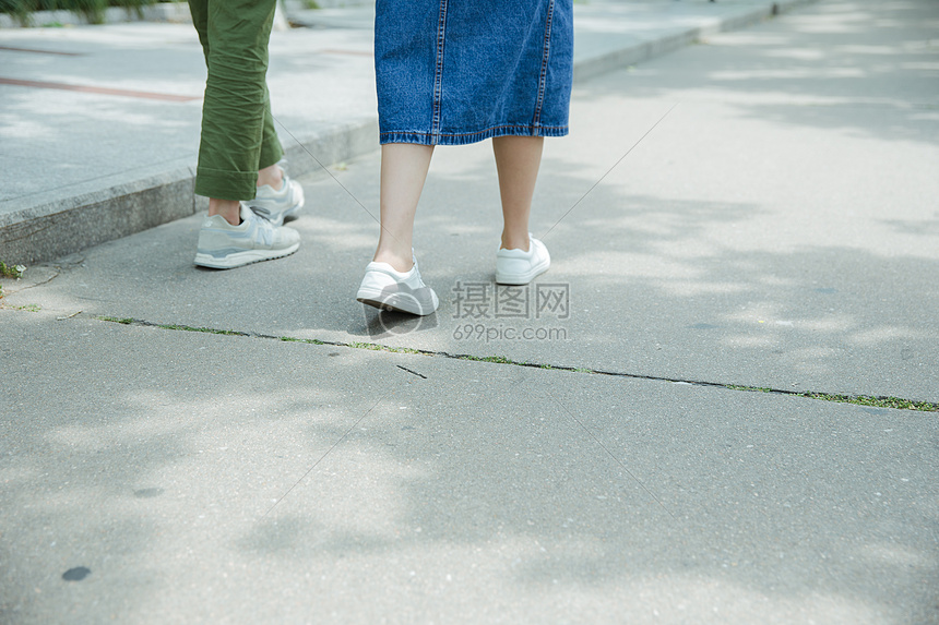 男女大学生走在路上脚部特写图片