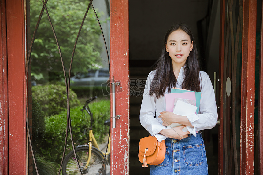 教室门前文静女大学生抱书形象图片