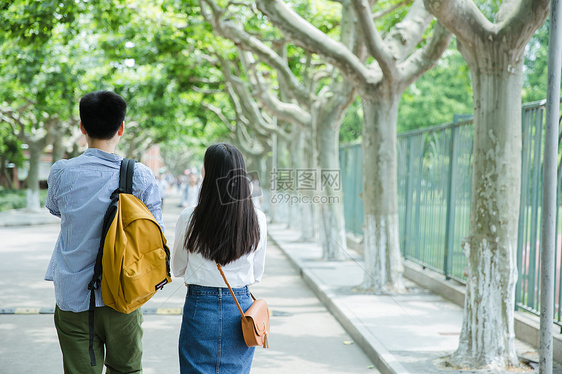 青春男女学生走在校园路上背影图片