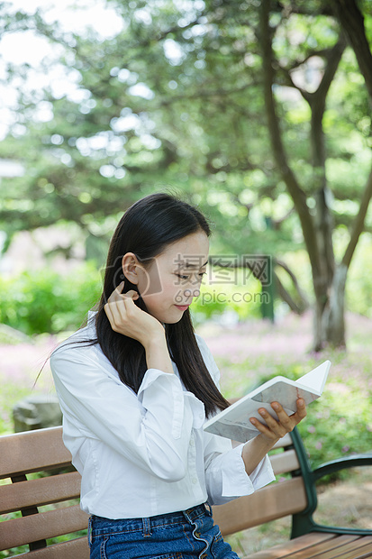 清新女大学生坐在椅子上看书图片