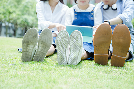 男女大学生看平板电脑鞋子特写图片