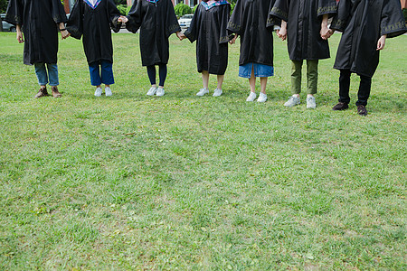 青春草地上大学生们牵手特写图片