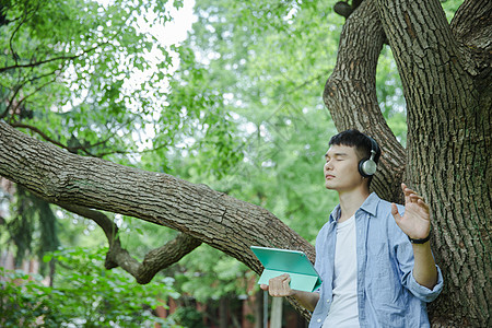 帅气大学生在用平板电脑听音乐图片