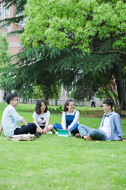 男女大学生们坐草地上聊天休息图片