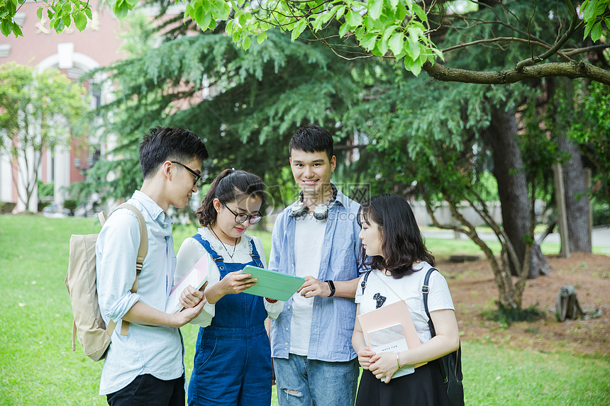 青春的大学生们在草地上讨论图片