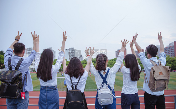 毕业季操场上青春大学们举手比耶图片