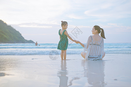 海边牵手的母子背影图片