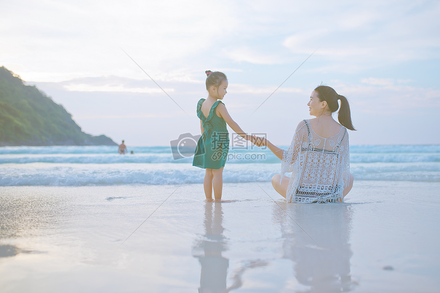 海边牵手的母子背影图片