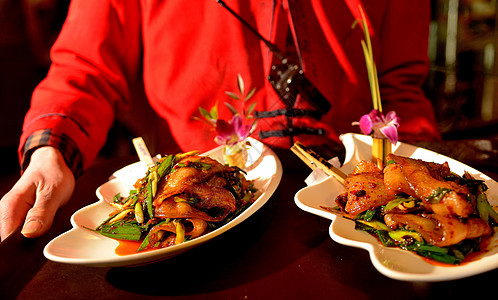 中国美食双手端着四川名菜回锅肉上菜背景