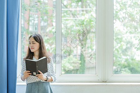 校园教室文艺甜美女孩拿着书背景图片