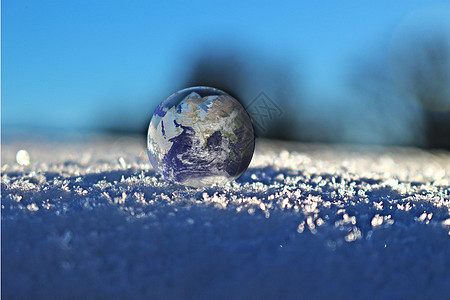 地上的人雪地上的玻璃地球设计图片